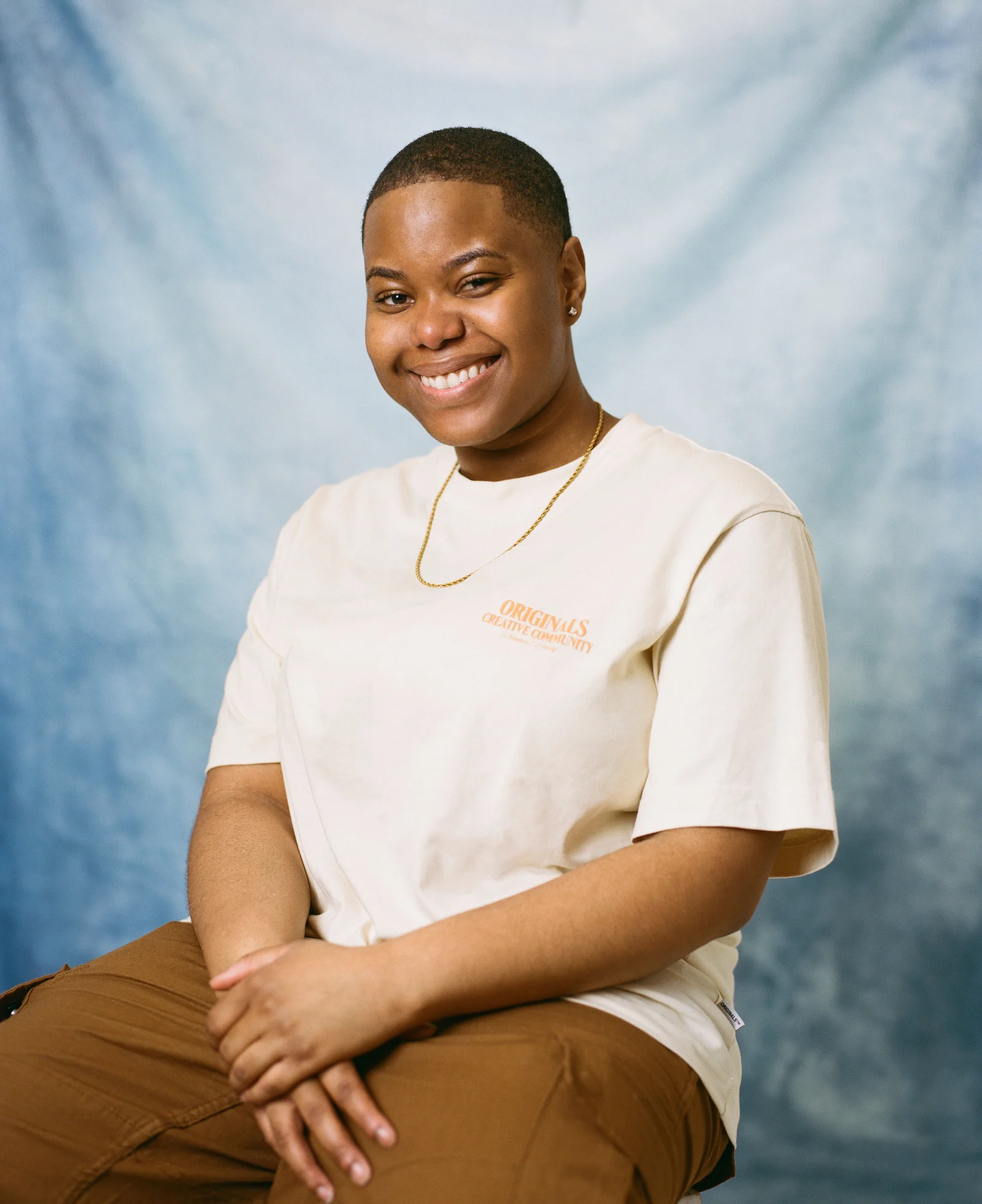 Elisabeth Clarke smiling in a white shirt against a blue backdrop