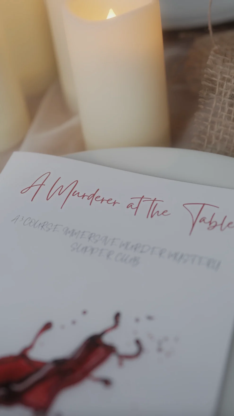 Printed A Murder at the Table programme beside a candle