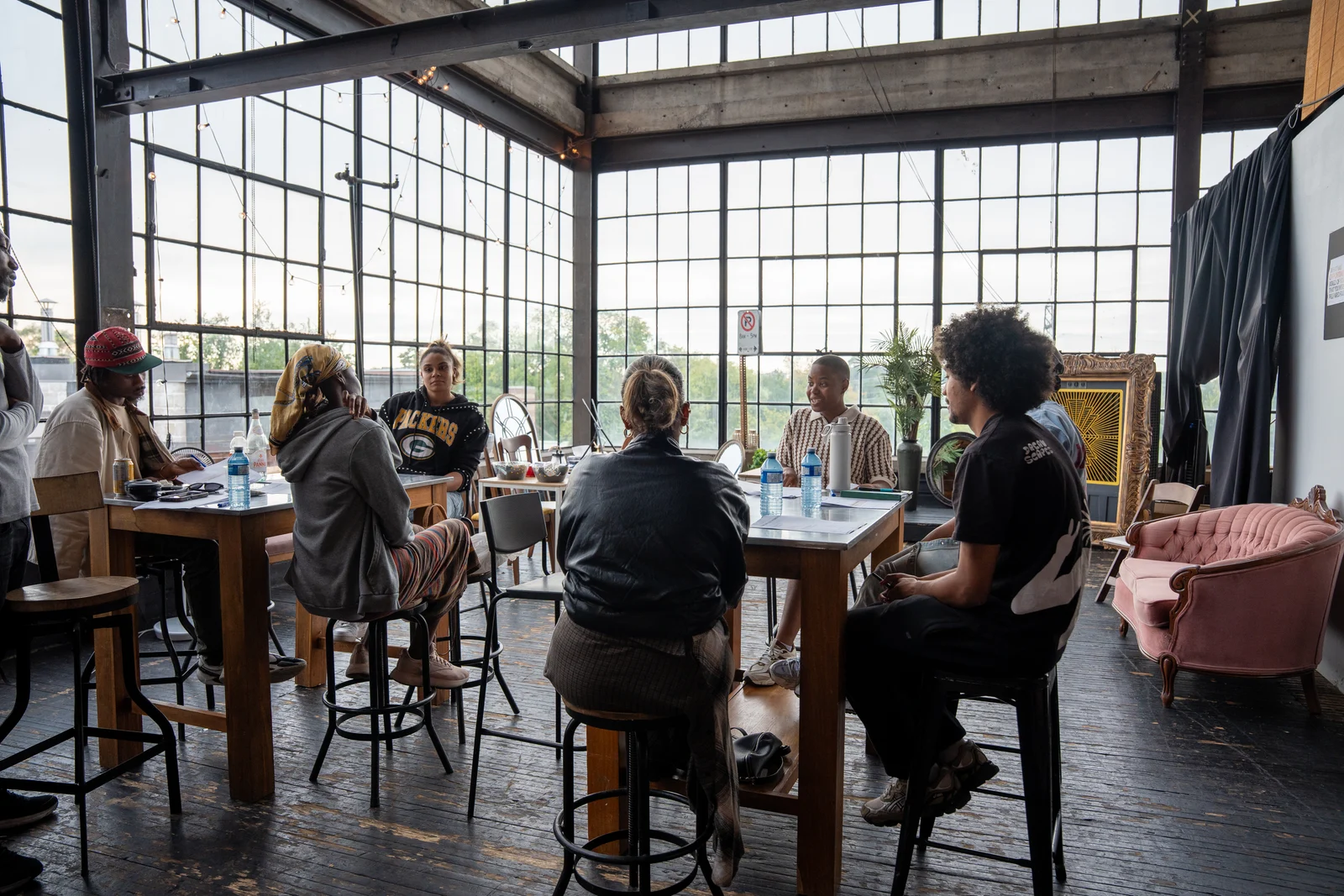 Participants gathered around working tables in a bright studio